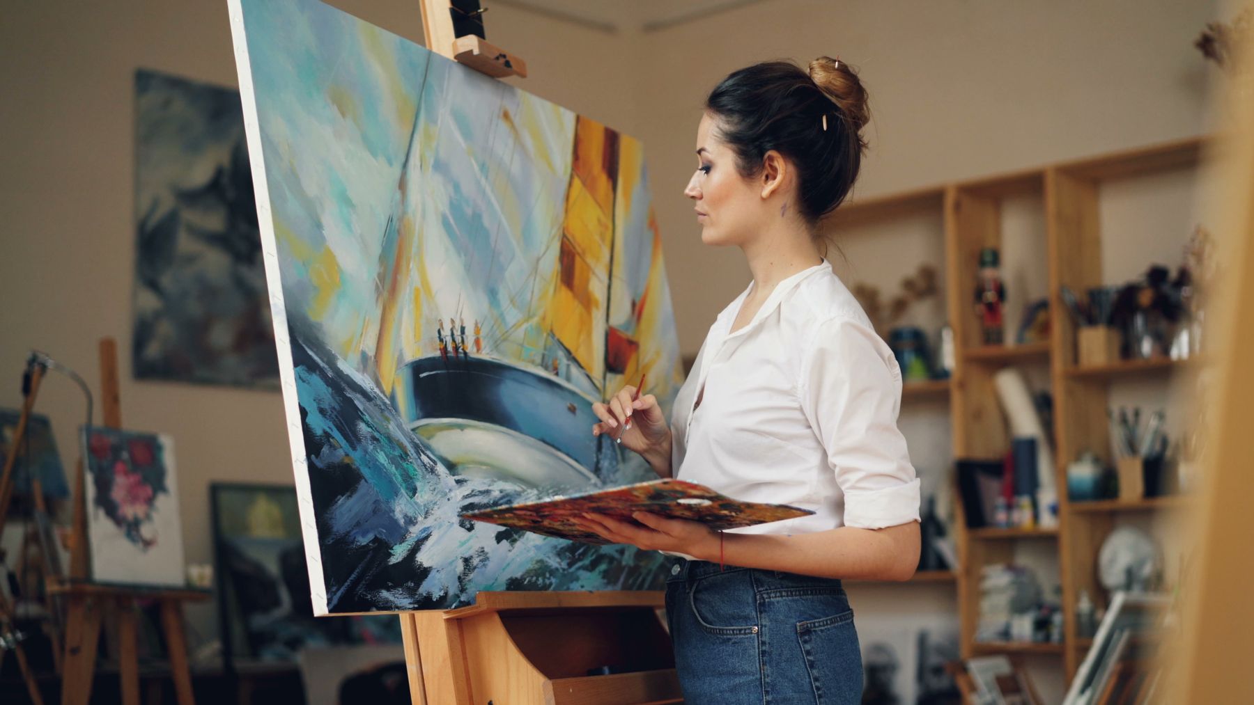 Artist painting an original canvas in a creative studio