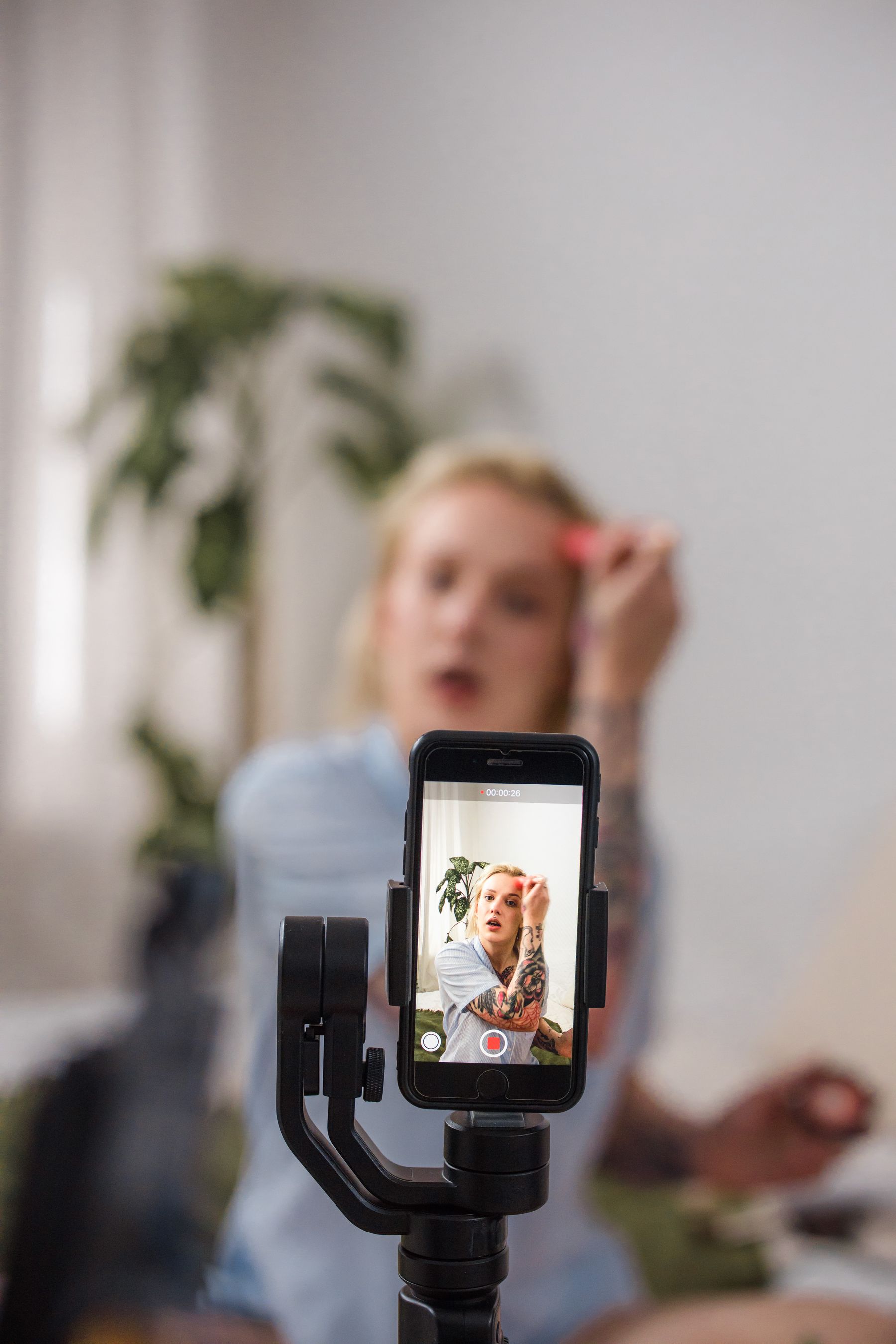 Beauty creator filming a makeup tutorial with a smartphone