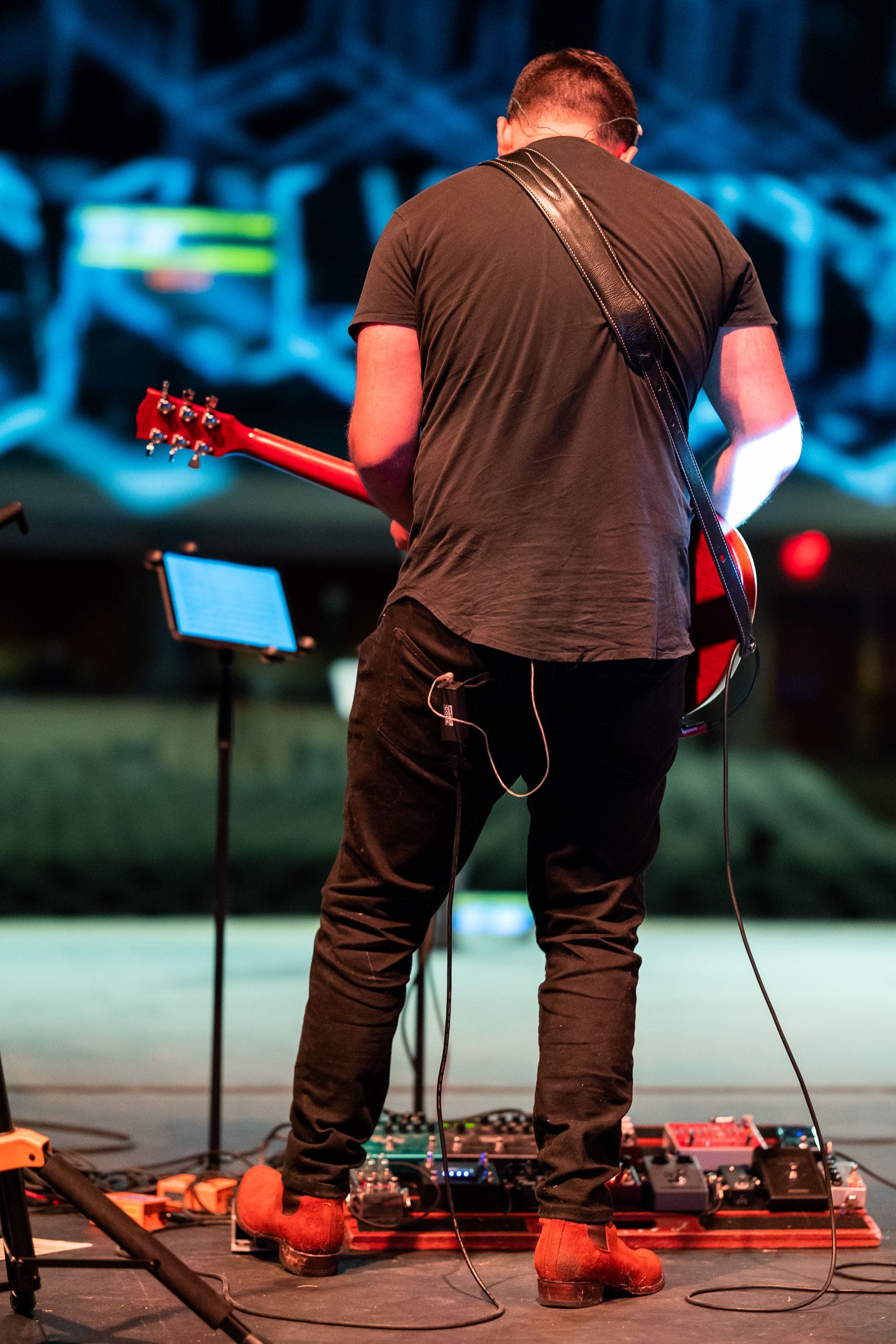 Guitarist performing live for an audience on stage