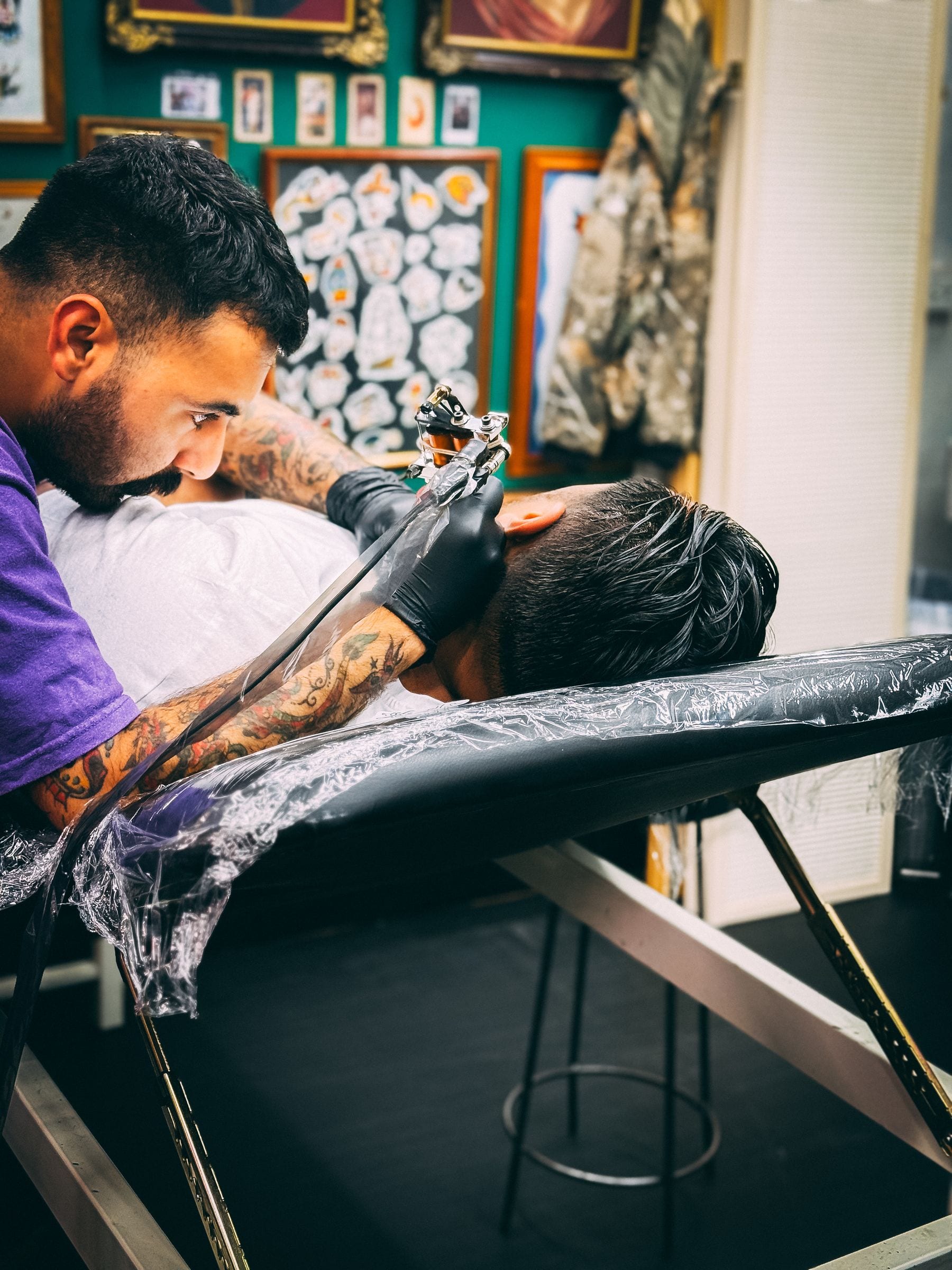 Tattoo artist working with a client in a professional studio