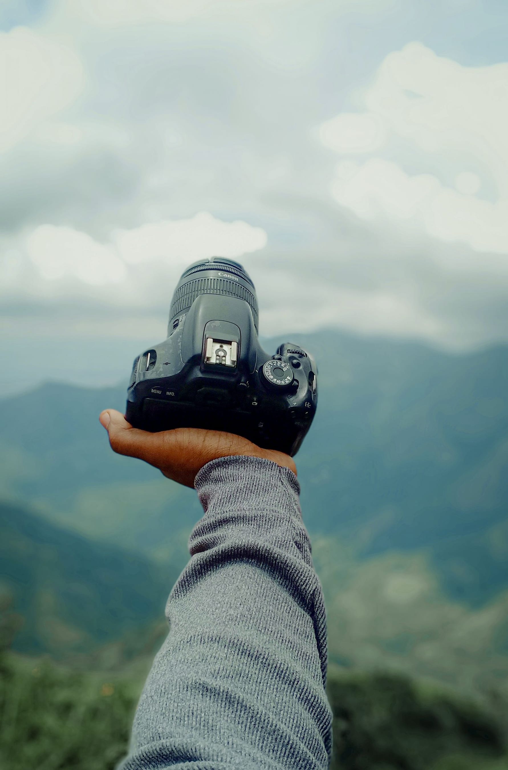 Travel photographer holding a camera while exploring outdoors