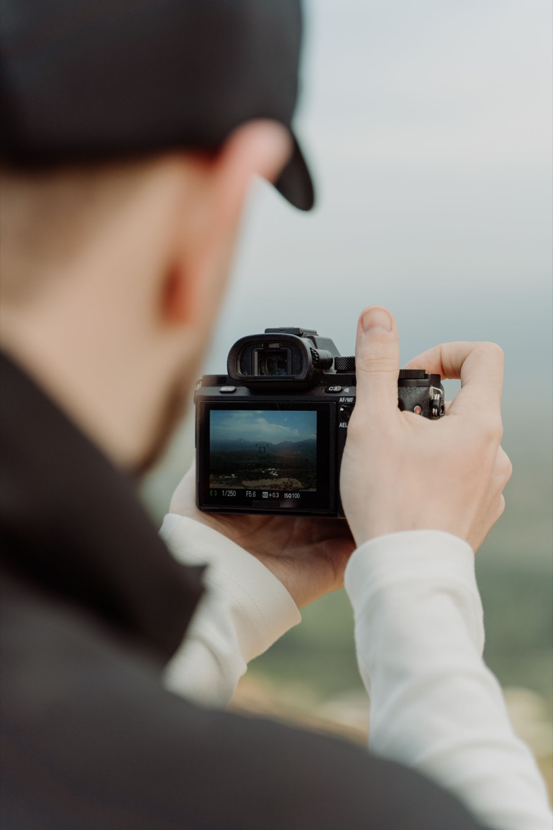 Photographer framing a landscape shot with a camera